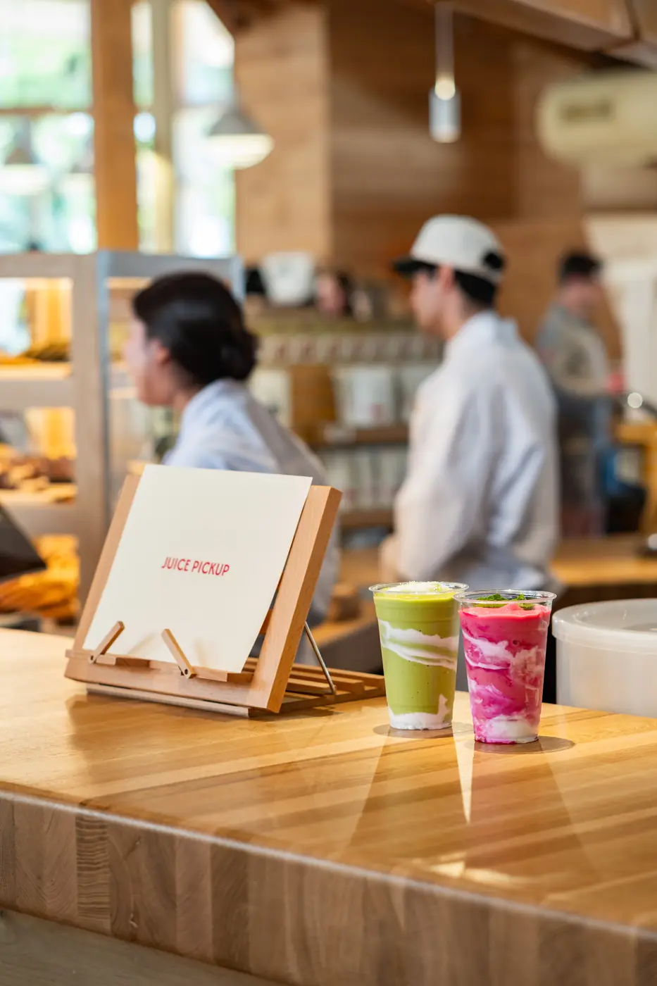 A green juice and a berry smoothie waiting at the juice pickup counter